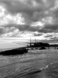 罗卡圣焦万尼La Via dei Trabocchi的海滩上码头的黑白照片