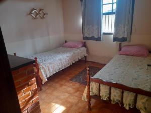 阿拉鲁阿马Cantinho da Lagoa的一间卧室设有两张床和窗户。