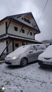 Crni VrhVila Kula的两辆汽车停在一座积雪覆盖的建筑前面