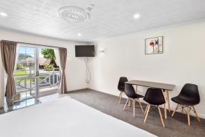 罗托鲁瓦艾舍乐格苑汽车旅馆 的配有一张床和一张桌子及椅子的房间