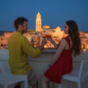 马泰拉The View Matera的男人和女人在阳台上喝葡萄酒