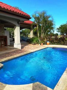 圣地亚哥Casa Dulce Vida Gran Pacifica Resort的一座大蓝色游泳池,位于房子前