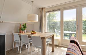 VlagtweddeAwesome Home In Vlagtwedde With Kitchen的一间带桌椅和窗户的用餐室