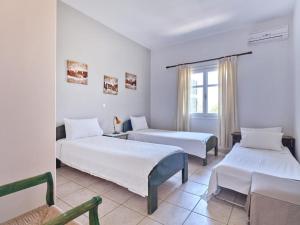 纳乌萨VILLA ALEXANDROS的酒店客房设有两张床和窗户。