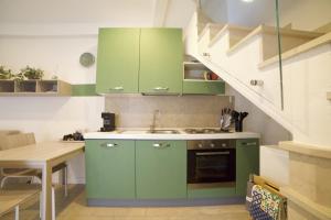 马罗内La brezza del lago的厨房配有绿色橱柜和水槽