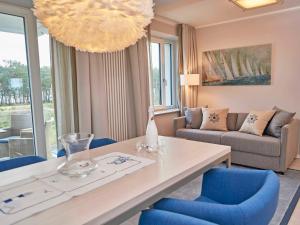 宾茨Strandresort Prora - WG 202 mit Meerblick und Sauna的客厅配有桌子和蓝色椅子