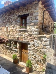 莱昂Elpajardeportilla的前方有窗户和植物的石头房子