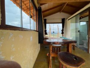 圣若热岛Chalé Beija Flor, venha viver essa experiência!!的客房设有桌椅和窗户。