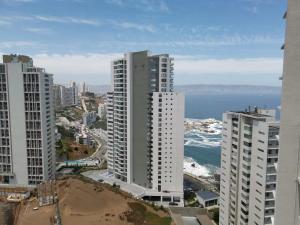 维纳德马Exquisito Departamento Reñaca en el sector más turístico的享有城市高楼和大海的景致