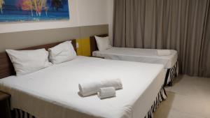 奥林匹亚Olímpia Park Resort-frente Thermas Laranjais-apt 5 p的两张位于酒店客房的床,配有毛巾