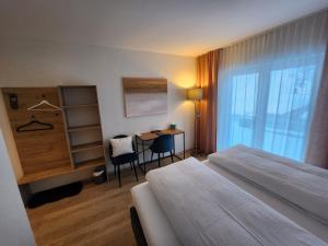 施瓦尔茨湖Pension fein & sein的配有一张床、一张书桌和一扇窗户的酒店客房