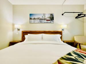 坎莫尔Joes Brand New 2 King Bedrooms Townhome in Canmore的卧室配有一张白色大床和一把椅子