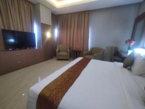 索龙Rylich Panorama Hotel的配有一张床和一台平面电视的酒店客房