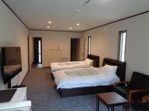 河津町Villa House Hisago - Vacation STAY 61410v的酒店客房,配有两张床和椅子