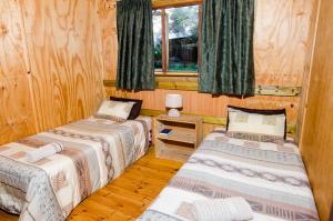 内尔斯普雷特河马水滨山林小屋的带木墙的客房内的三张床