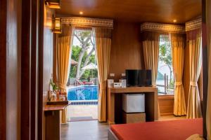 小通奈潘Panviman Resort Koh Phangan - SHA Extra Plus的客厅设有黄色窗帘和大窗户