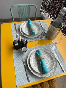 圣丹尼斯T2 Saint-Denis -Jardin de l'Etat的一张黄色桌子,上面有盘子和餐具