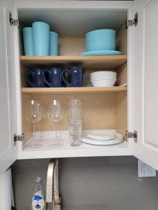 奥兰多3509 Luxury Location and Location的厨房橱柜配有盘子、玻璃杯和水槽