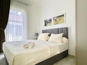 庞岸达兰De Residence Pangandaran by Mabano Estates的一间卧室配有一张大床和毛巾