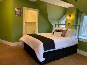海伦娜Pope House - Hist. Mansion - The Green Suite的一间卧室设有一张带绿色墙壁的大床
