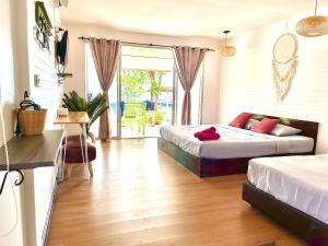 格兰岛Insook Ko Larn Resort的一间带两张床的卧室和一间客厅
