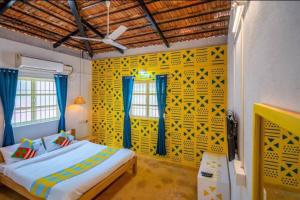 果阿旧城Luxury 6 BHK Villa with Private Swimming Pool的一间卧室设有一张床和黄色的墙壁