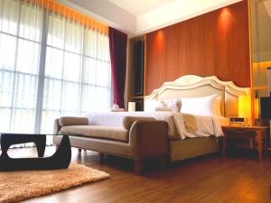 纳仲天Grand Lord Hotel & Residence的一间卧室配有一张床和一张沙发