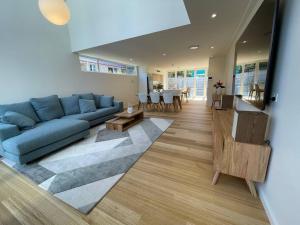 麦夸里港Noahs Beach House - at Flynns的客厅配有蓝色的沙发和桌子