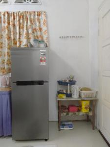 Pasir MasLayya Homestay的厨房配有冰箱和桌子