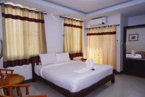清迈Tamnak Lanta @Chiang Mai的卧室配有一张带窗帘和水槽的白色大床