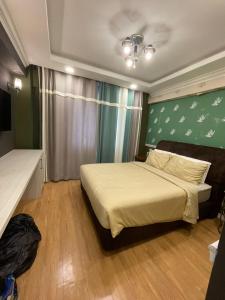 莎阿南Illusyin Retreat的一间卧室设有一张床和绿色的墙壁