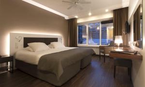 鹿特丹艾玛酒店的一间卧室设有一张大床和一个窗户。