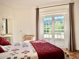 本萨夫林Casa da Aldeia的一间卧室设有一张床和一个大窗户