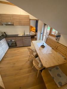 塞斯托Apartments Unteradamerhof的厨房铺有木地板,配有木桌。