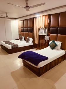 新德里Hotel Cozy Cave Delhi Aiport的一间卧室设有两张床,墙上配有电视。