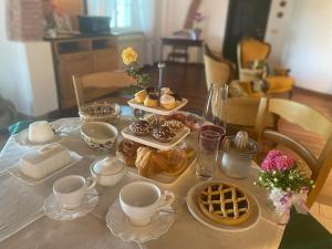 帕贾尼克Il Casale delle Rose的餐桌,带糕点、杯子和盘子