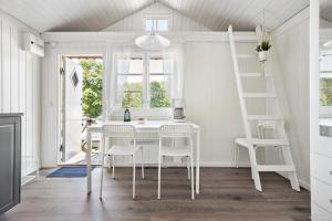 尼奈斯港First Camp Nickstabadet-Nynäshamn的白色的用餐室配有白色的桌椅