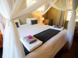 侯斯普瑞特Kum Kula Lodge的卧室配有白色床和毛巾