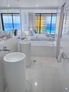 黄金海岸Tower 1 Oracle 16th floor Stunning views的白色的浴室设有浴缸和床。