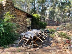 FaradayRustic miners cabin的一组椅子和一张桌子,一座石头建筑