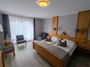 林根尊姆马赫瓦尔德酒店的酒店客房带一张大床和一把椅子