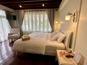Ban Lum Thanเซน บัลโคนี่ เฮ้าส์ ระนอง的一间卧室配有一张床、一把椅子和一张桌子