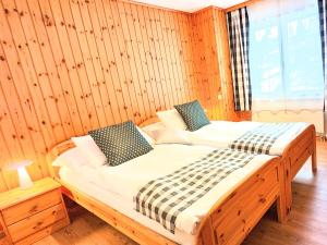 兰达瓦利斯兰达贝采尔马特公寓的卧室配有木墙内的两张床