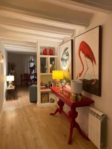 韦斯卡Apto. centro histórico Huesca的客厅配有一张桌子,墙上挂着鸟画