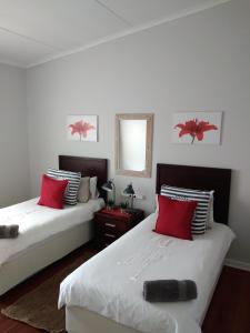 斯瓦科普蒙德20 on Beach Road的一间卧室配有两张带红色枕头和镜子的床
