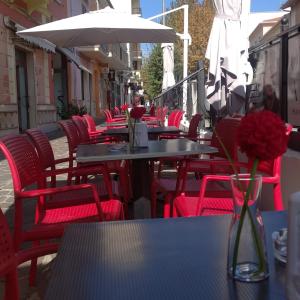 托尔托拉Beb Alla Marina Tortora的一排桌子,有红色的椅子和花瓶