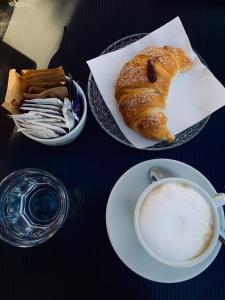 托尔托拉Beb Alla Marina Tortora的一张桌子,上面放着一盘面包和一杯咖啡