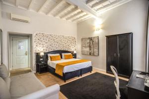 罗马Relais Fontana Di Trevi Hotel的一间卧室配有一张特大号床和一张沙发