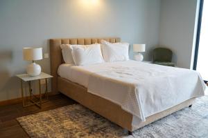 Faja GrandeVillas do Mar的卧室配有一张带白色床单和枕头的大床。