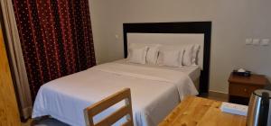 基加利Traveller's StaY的一间卧室配有带白色床单和枕头的床。